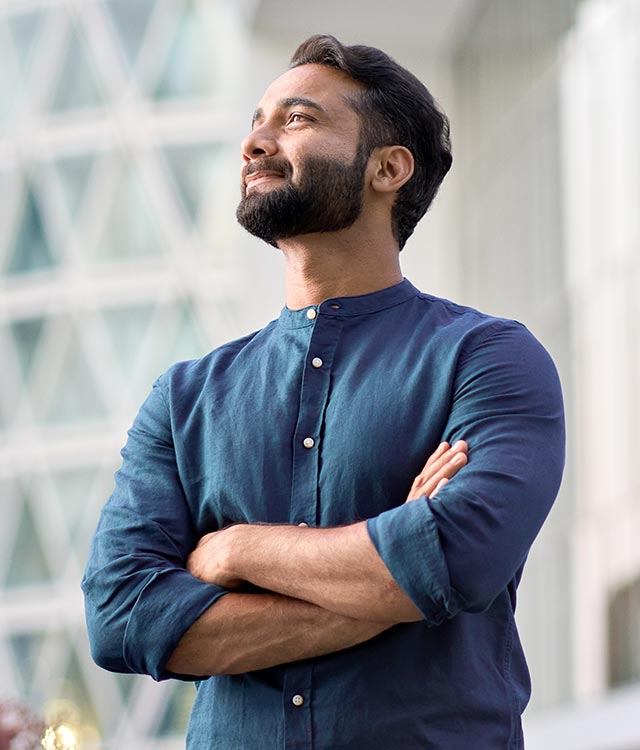 Confident man standing with arms crossed outdoors