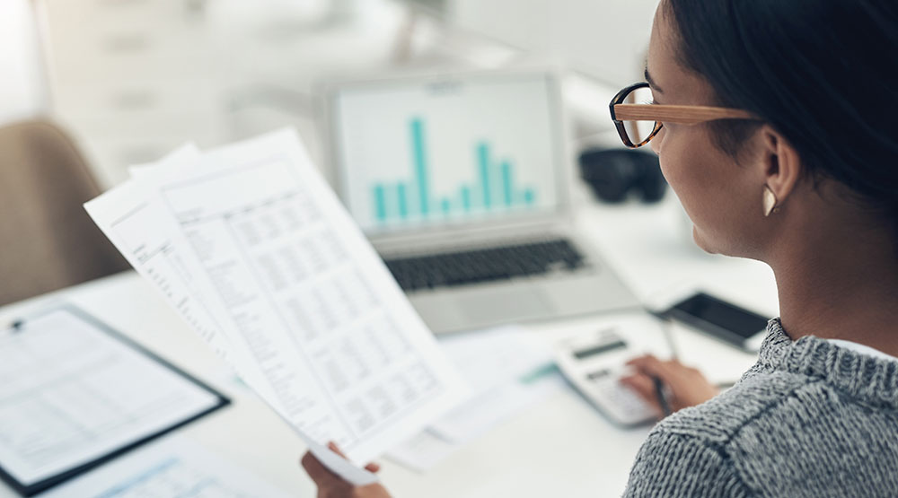 Woman reviewing financial documents at desk