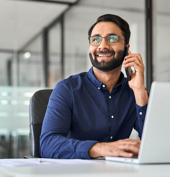 Smiling professional on phone at desk