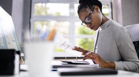 Focused woman calculating numbers on desk